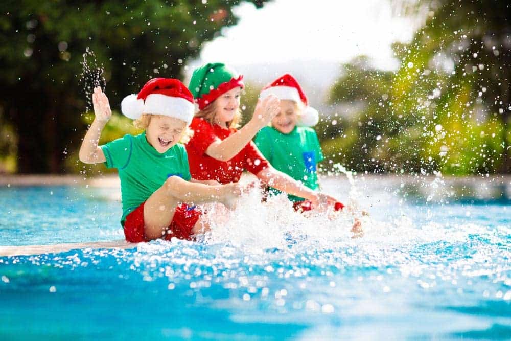 Children Wearing Santa Hat Playing By The Pool