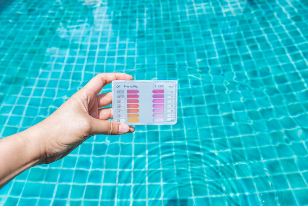 Water Testing Test Kit In Girl Hand Dipping In Clear — Hi-Tech Pools & Spas In Yarawonga, NT